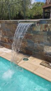 une fontaine dans la piscine dans l'établissement Hermosa casa en barrio la toma, à Capilla del Monte