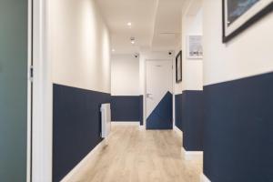 a hallway with blue and white walls and a door at Port 56 in Portstewart