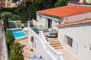 a villa with a swimming pool and a house at VILLA BELLE VUE VI4394 By Riviera Holiday Homes in Villefranche-sur-Mer