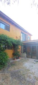 une maison jaune avec des plantes devant elle dans l'établissement Hermosa casa en barrio la toma, à Capilla del Monte