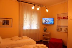 a bedroom with two beds and a tv on the wall at Affittacamere Da Lina in Vittorio Veneto