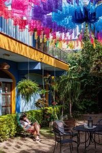 Azul Cielo Hostel في مدينة أواكساكا: امرأة تجلس على أرجوحة في حديقة