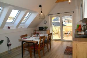 una cucina e una sala da pranzo con tavolo e sedie di Apartments Ajda a Bohinj Altre 25 foto