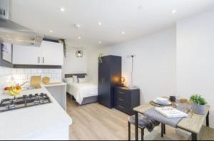 The Residency rooms Liverpool في ولاسي: مطبخ وغرفة معيشة مع سرير وطاولة