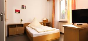 Cette petite chambre comprend un lit et une télévision. dans l'établissement Hotel zum Alten Wirt, à Langenbach