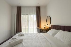 - une chambre avec un grand lit blanc et des serviettes dans l'établissement Sobi Village, à Oseshchino