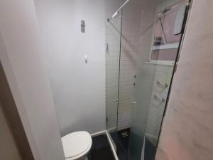 uma casa de banho com um WC e uma cabina de duche em vidro. em Suhcasa Leme Studio Confort no Rio de Janeiro
