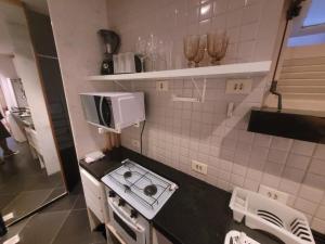 a small kitchen with a stove and a microwave at Suhcasa Leme Studio Confort in Rio de Janeiro