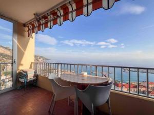 a balcony with a table and chairs and a view of the ocean at Menton - Vue panoramique exceptionnelle ! 4Pers in Menton