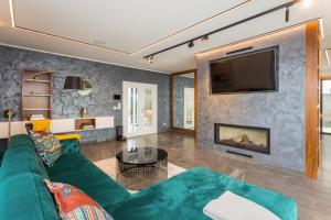 uma sala de estar com um sofá verde e uma lareira em Platinum em Opatija