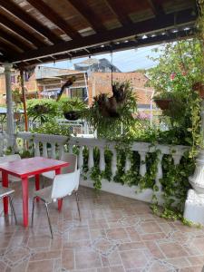a patio with a table and chairs and a fence with plants at HOTEL VILLA DANIELA in Puerto Triunfo