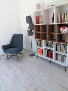 a living room with a chair and a book shelf at Casa Fraga do Suadouro in Campo do Gerês