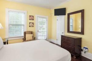 1 dormitorio con cama, espejo y tocador en Curry House - Room 2, en Key West