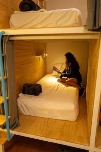 a woman sitting on a bed in a bunk bed at Azul Cielo Hostel in Oaxaca City