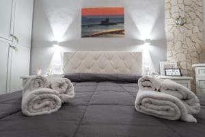 a bedroom with a large bed with towels on it at Casa Iraci La Nostra Sicilia in Trapani