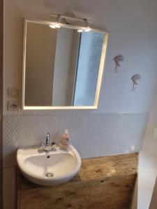 a bathroom with a white sink and a mirror at Joli appartement rénové (Hirondelle) in Cornimont