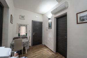 a hallway with a room with a table and a door at Casa Iraci La Nostra Sicilia in Trapani