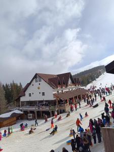 a group of people standing in front of a ski lodge at Pensiunea Tania in Ranca