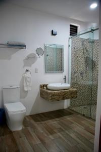 a bathroom with a toilet and a shower and a sink at Hotel Boutique Eden Costa in Santa Cruz Huatulco