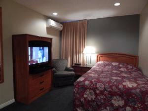 um quarto de hotel com uma cama e uma televisão em Nox Hostel em Toronto