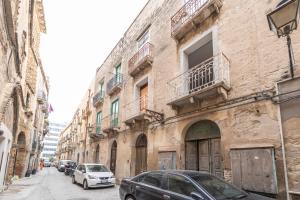 a street with cars parked in front of buildings at Casa Iraci La Nostra Sicilia in Trapani +64 photos