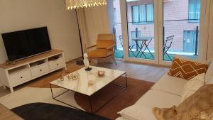 - un salon avec un canapé et une télévision dans l'établissement Courbevoie lodge, à Louvain-la-Neuve