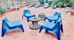 - un ensemble de chaises bleues et une table sur une terrasse dans l'établissement Apartamentos Gran Via Musicales, à Madrid