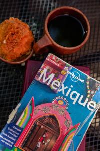 Azul Cielo Hostel في مدينة أواكساكا: مجله وكوب من القهوه ووعاء من الطعام
