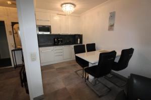 - une cuisine avec une table et des chaises dans la chambre dans l'établissement Haus Norderhoog Wohnung 31, à Westerland