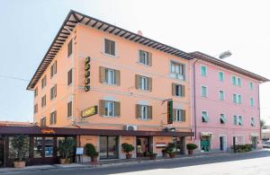 a large pink building on the side of a street at Hotel Il Ponte in Cecina