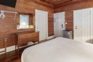 Un dormitorio con una cama y una pared de madera. en Curry House - Rooms 3 & 4, en Key West