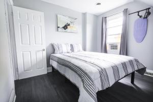 biała sypialnia z łóżkiem i oknem w obiekcie Comfy Micro Apartment 1BR 1 Bath close to the falls w mieście Niagara Falls