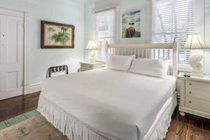 a bedroom with a large white bed and two night stands at Curry House - Room 5 in Key West