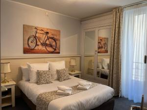 ヴィシーにあるLogis Hôtel Belle Etoile Vichyのベッドルーム1室(壁に自転車を設置したベッド1台付)