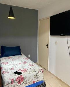 - une chambre avec un lit et une télévision à écran plat dans l'établissement Quarto/sala Região central, à Macaé
