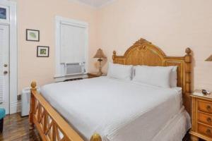 Un dormitorio con una gran cama blanca y una ventana. en Curry House Room 6, en Key West