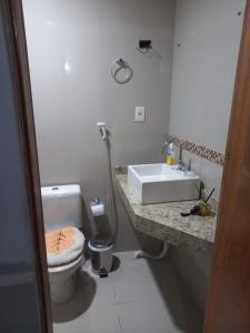 a white bathroom with a toilet and a sink at Hotel Palace in Porto Alegre