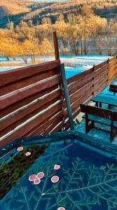 a hot tub with a bench and flowers on the ground at Guest House Pid Dubom Карпати Під Дубом in Skole