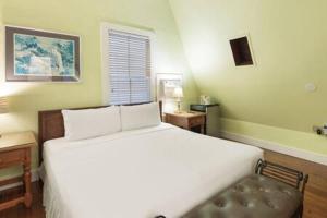 a bedroom with a white bed and a bath tub at Curry House - Pool, King Bed & Balcony! Room 7 in Key West