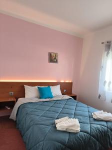 a bedroom with a bed with two towels on it at Apartamentos Campos 2 in Porto Covo