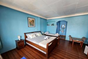 Un dormitorio con paredes azules y una cama con un osito de peluche. en Little Mermaid Dive Resort, en Isla de Malapascua