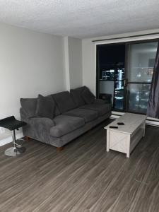 a living room with a couch and a table at Appartement 2 Chambre neuf in Longueuil