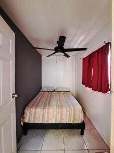 a bedroom with a bed with a ceiling fan at CASA FOTR LOCO in Uvita