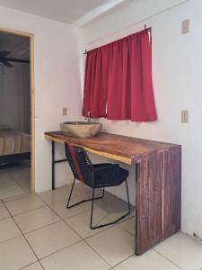 a bathroom with a sink and a red curtain at CASA FOTR LOCO in Uvita