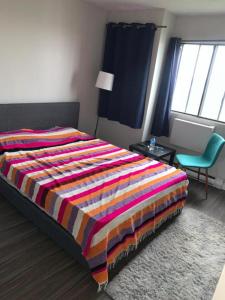 um quarto com uma cama com um cobertor colorido em Appartement 2 Chambre neuf em Longueuil