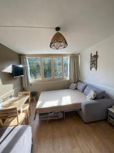 a living room with a large bed and a couch at Appartement résidence le bec de l’aigle in Laveissière
