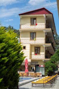 un hotel con piscina frente a un edificio en Hotel Chveni Ezo, en Kobuleti