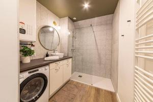 a bathroom with a washing machine and a shower at L'Azur chaleureux et cocooning in Segré