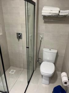uma casa de banho com um WC e uma cabina de duche em vidro. em Hotel das Américas em Balneário Camboriú