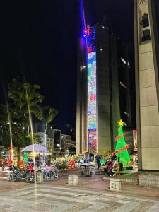 uma árvore de Natal iluminada em frente a um edifício em Lindo apto amoblado ¡super central! RNT734 em Armenia